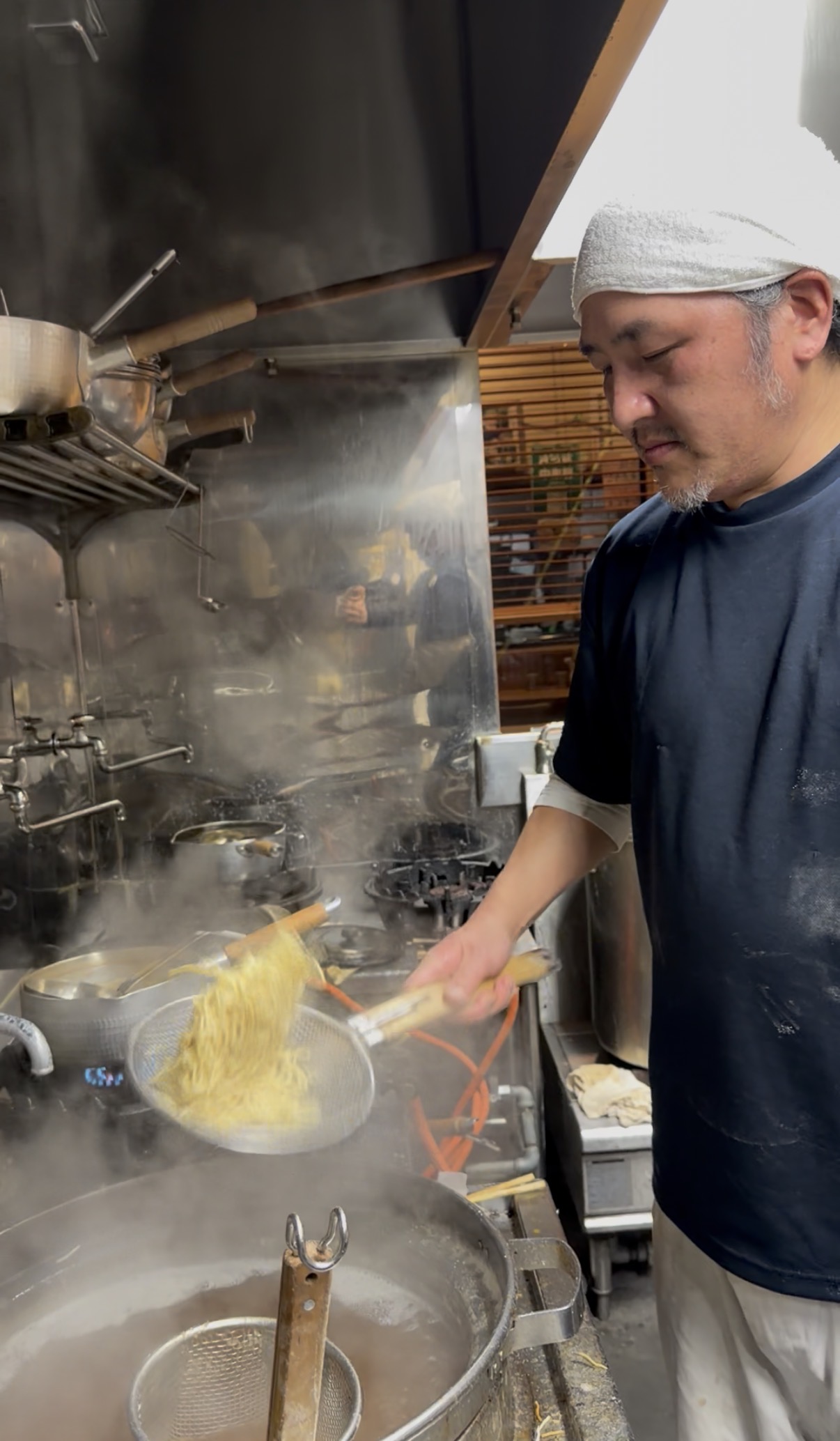 厨房で調理をする店主